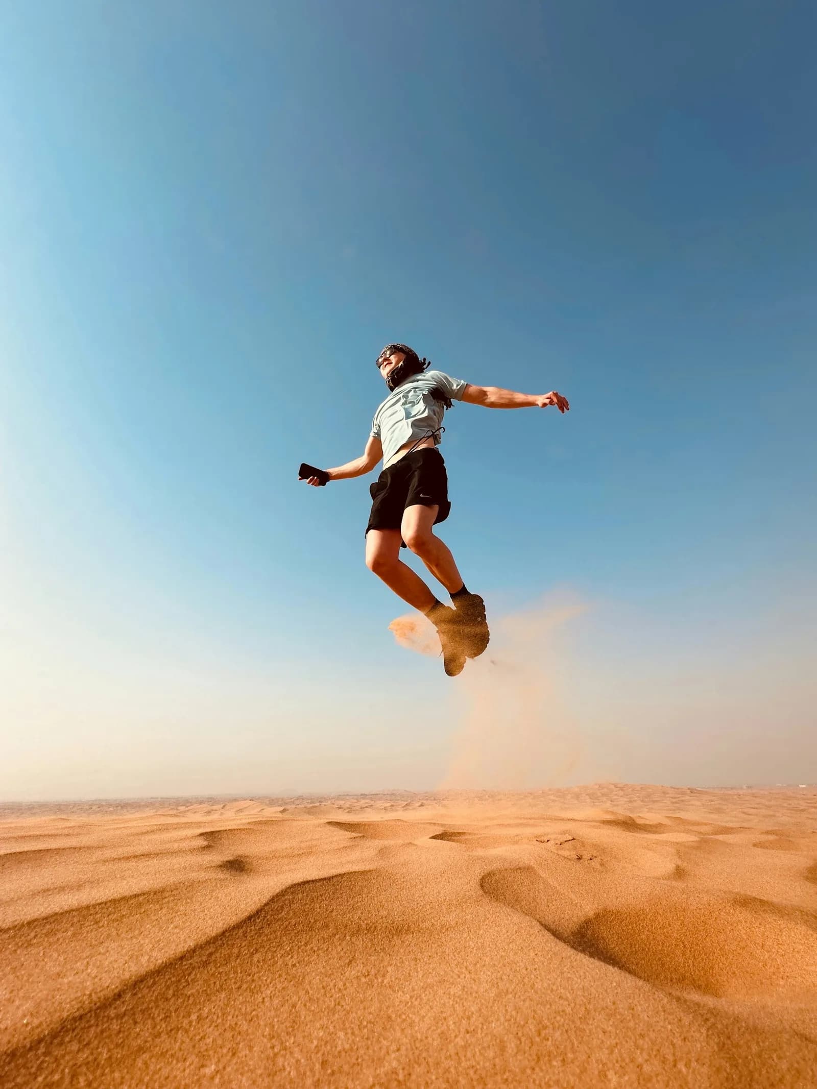Sandboarding down a steep dune in the Dubai desert — photo 2