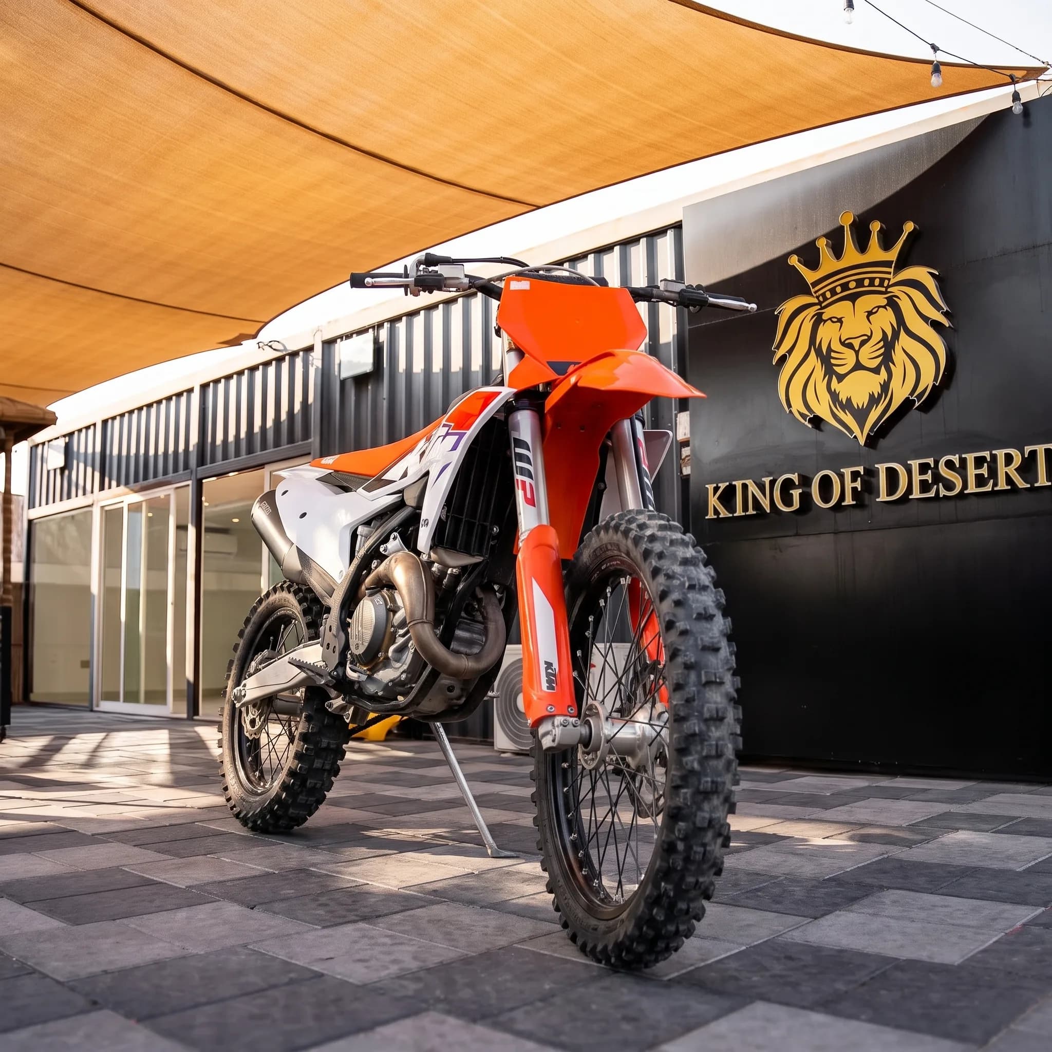 KTM 450 SX-F dirt bike parked outside the King of Desert showroom in Dubai