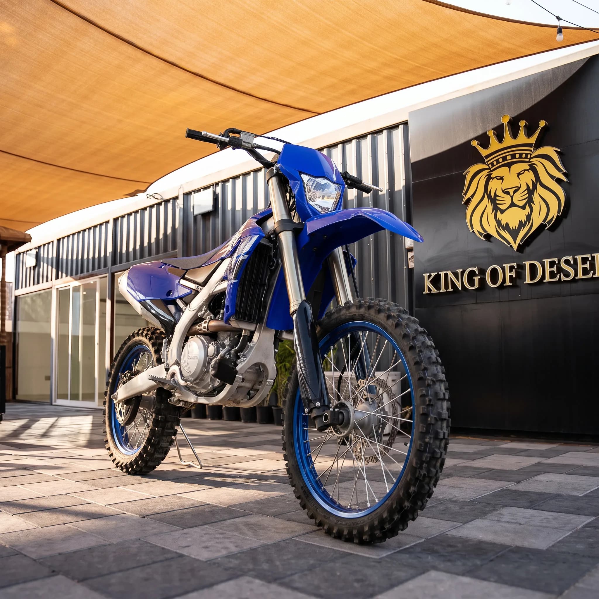 Blue Yamaha YZ450F dirt bike parked outside the King of Desert showroom in Dubai