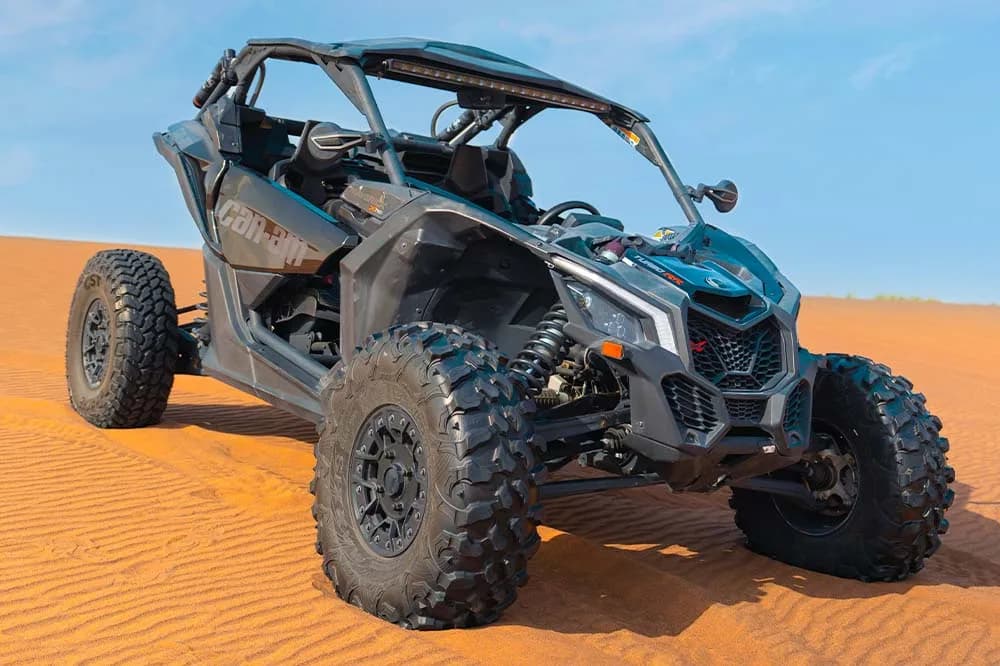 Can-Am X3 Turbo 2-seat dune buggy racing across Dubai desert dunes